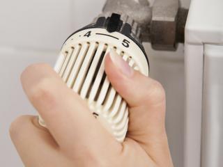 Person adjusting radiator thermostat